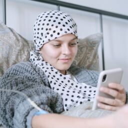 woman in bed using her smartphone