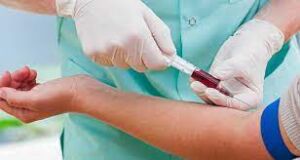 Phlebotomist performing lab tests, withdrawing blood from someone's arm