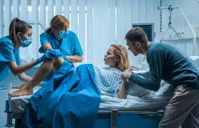 Woman in labor delivering a baby with medical professionals assisting