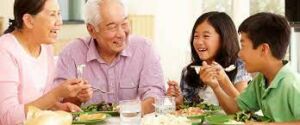 A happy family sitting together at the dining table, enjoying a meal with each other.