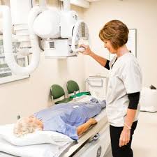 Close-up of an X-ray machine, with a patient positioned for a scan to assess bone health.