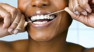 Close-up of hands holding dental floss, demonstrating proper flossing technique.