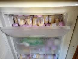 Several bottles of expressed breast milk stored in a freezer, organized for later use.