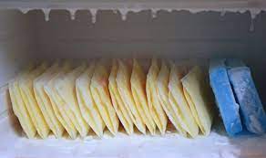 Several packs of frozen breast milk, carefully organized in a freezer compartment.