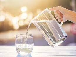 A jug of water being poured into a glass, illustrating freshness and clarity.