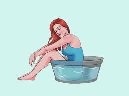 Woman sitting in a tub of water, performing a sitz bath to relieve postpartum discomforts