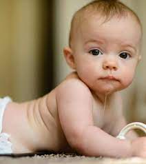 Drooling child lying on abdomen 