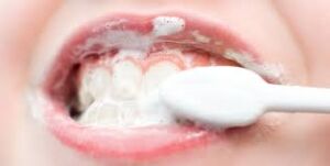 Child brushing their teeth to promote dental hygiene