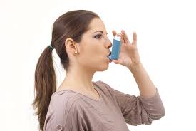 a woman using an inhaler in a natural indoor setting.