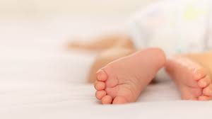 A close-up of a baby's tiny foot, soft and delicate.