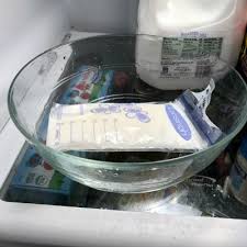 A frozen breast milk pack thawing in a bowl of water, preparing for feeding.