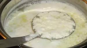 A pan with milk gone bad, showing curdles and an unpleasant texture.