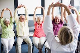 Elderly fitness class: A small group of seniors engaging in exercises together, promoting health, wellness and fatigue relief during Move More Month.