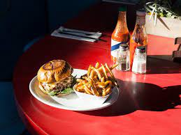 Image depicting a spread of unhealthy foods, such as a burger and fries, contributing to the impact of sugar on brain health.