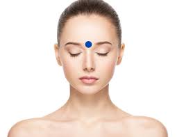 The Third Eye pressure point located between the eyebrows for relief of headaches, relaxation and focus