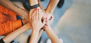 Multiple Sclerosis Awareness Week: Supporting Each Other with Hope - Group of hands stacked in unity