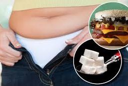 Image of a person struggling to fit into tight jeans, highlighting the importance of mindful eating habits and portion control for weight management.