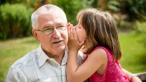 Child whispering in elderly man's ear