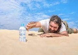 Thirsty person in the desert reaching for a bottle of water: Recognizing signs of thirst