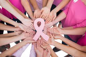 Womens wellbeing: Group of women supporting breast cancer awareness with pink ribbon