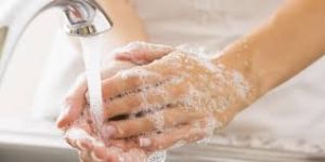 Person washing their hands under running water: Proper hand hygiene with soap and water.