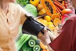 A person measuring their blood pressure surrounded by assorted fruits and vegetables