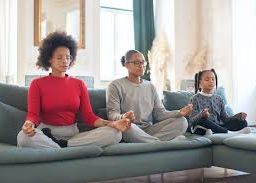 Woman and her children sitting on the couch meditating