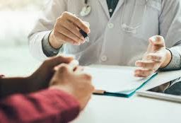 Person receiving medical advice while attending a preventive care check-up with a doctor.