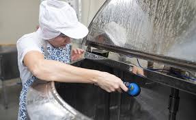 Person practicing safe food handling by cleaning the stove