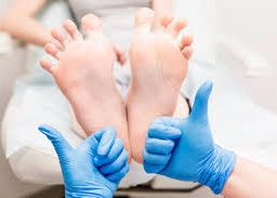 Gloved thumbs up beside healthy feet - Celebrating successful practices for diabetes and circulatory health.