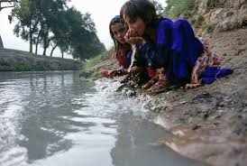 Person safely drinking water from a lake, emphasizing the importance of clean water sources.
