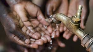 Persons collecting water under a pipe with their hands