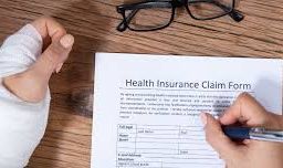 Person filling out a claim form, showcasing the initial step in the health insurance claims process for seeking coverage and managing medical expenses.