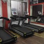 Array of treadmill equipment at the gym, showcasing the diverse options available for cardiovascular workouts and highlighting the importance of adhering to health warnings for user safety.