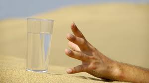 Person's hand reaching for a glass of water, emphasizing the diabetes warning signs related to excessive thirst.