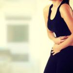 Woman in discomfort, holding abdomen in pain