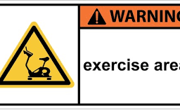 Warning sign for exercise equipment with a cautionary message about proper usage and safety precautions.