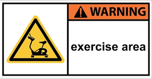 Warning sign for exercise equipment with a cautionary message about proper usage and safety precautions.