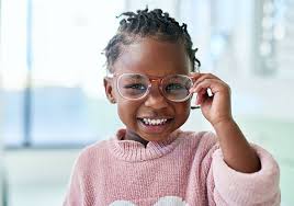 Girl happily wearing prescription glasses for improved vision.