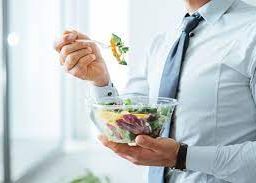 Man enjoying a nutritious salad, showcasing a commitment to healthy nutrition and wellness.