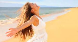 Woman with Open Arms Enjoying the Sun - Embracing Nature and Vitamin D Benefits