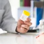 Doctor offering cup to patient