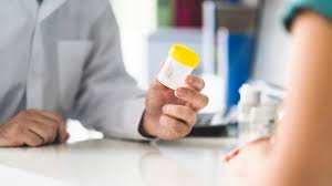 Healthcare professional offering cup to patient