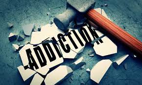 Image of a hammer resting on broken tiles labeled 'addiction,' symbolizing the breaking of the cycle of addiction.