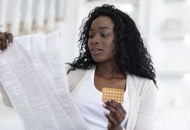 Woman holding a packet of pills in her hand