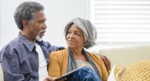 happy elderly couple seated on a sofa, challenging healthcare myths about aging