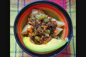 a plate of avocado. green figs and salt fish, a Saint Lucian dish