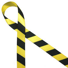 Yellow caution ribbon with black stripes, symbolizing a warning or alert to potential danger or restricted areas.