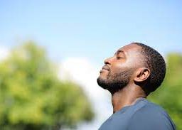 Man inhaling deeply, symbolizing the essence of respiratory health and fresh air intake.
