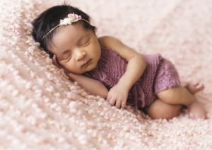 Premature baby girl peacefully asleep on a warm blanket.